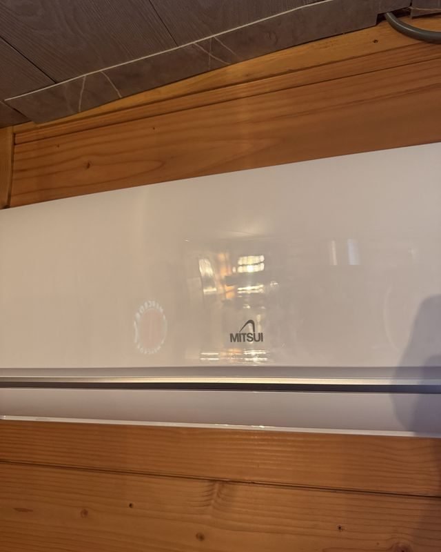 Binnenunit van de airco tegen de houten wand van de schuur